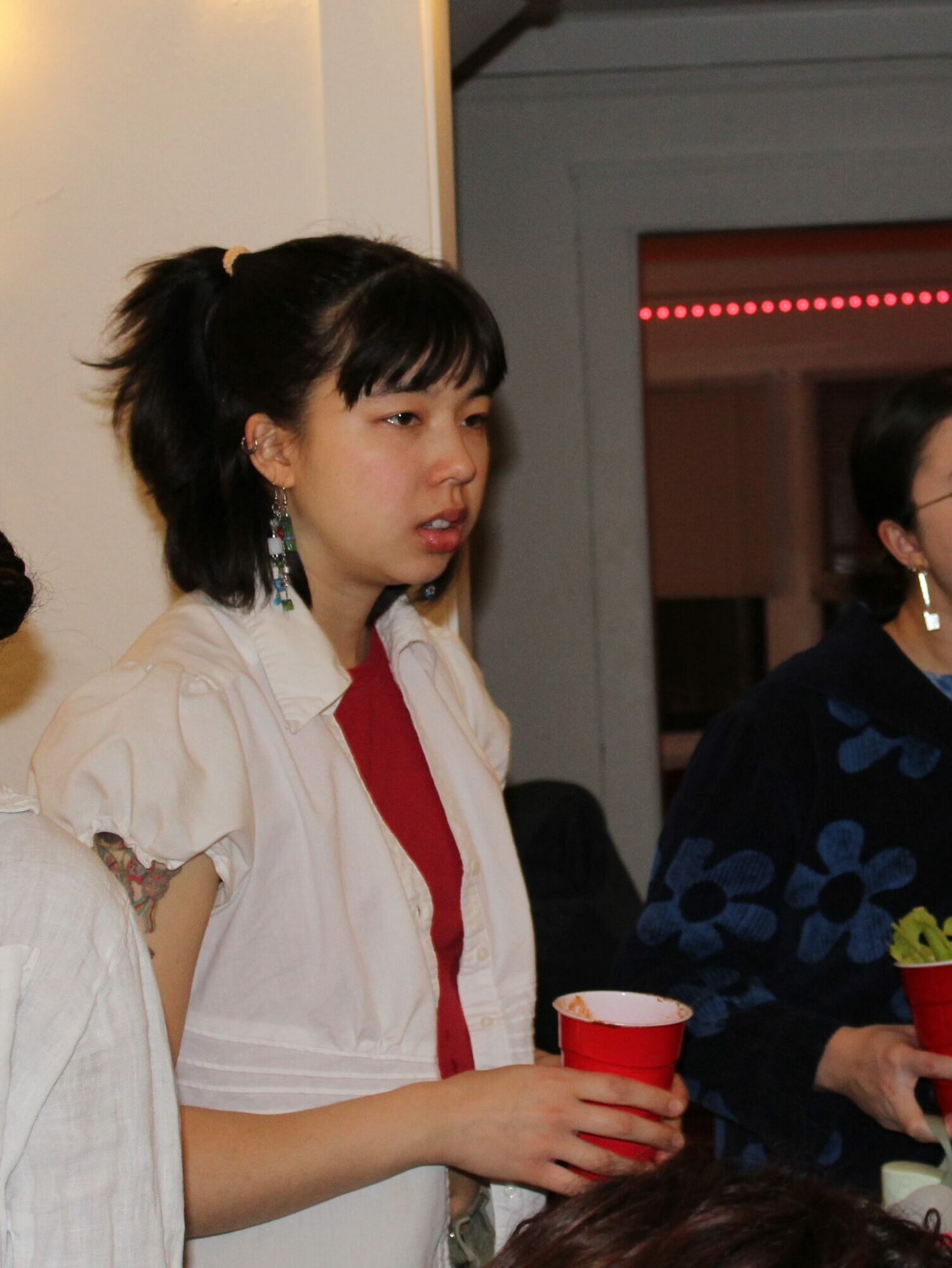 Lanie Cheatham holds a bloody mary in a red solo cup and looks to the right.