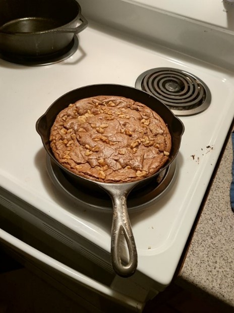 1890s Erie cast iron skillet with large cookie inside, sitting on a stove.