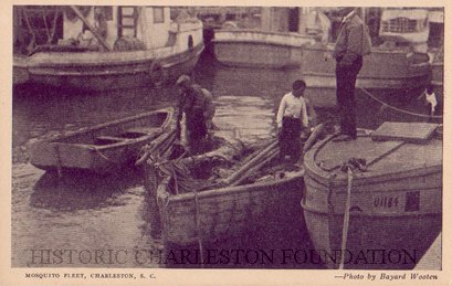A black and white photograph depicting three men of the Mosquito Fleet standing on their fishing boats in a harbor. 
